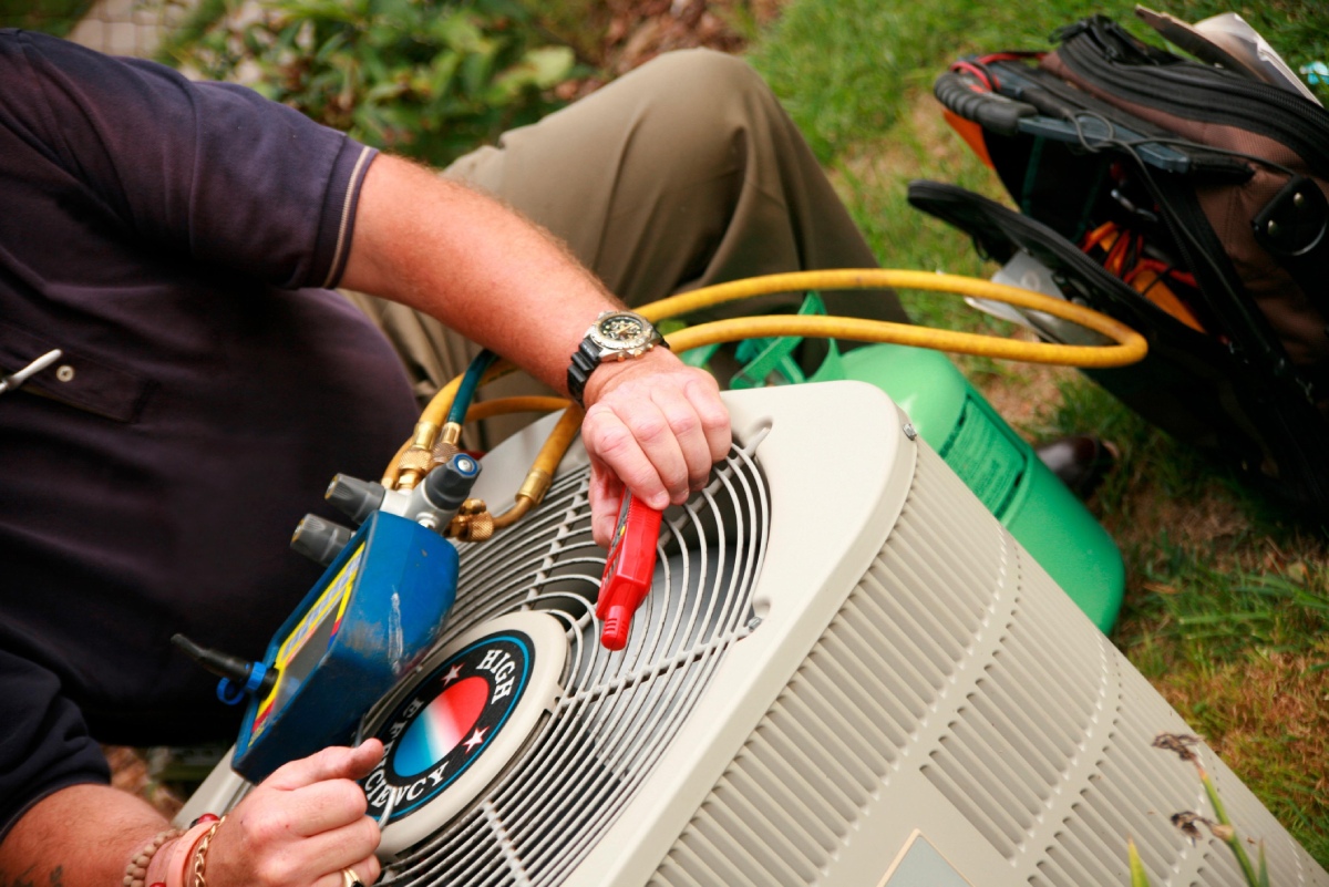 J&D HVAC technician inspecting an AC unit showing signs of failure in Fort Myers, Florida